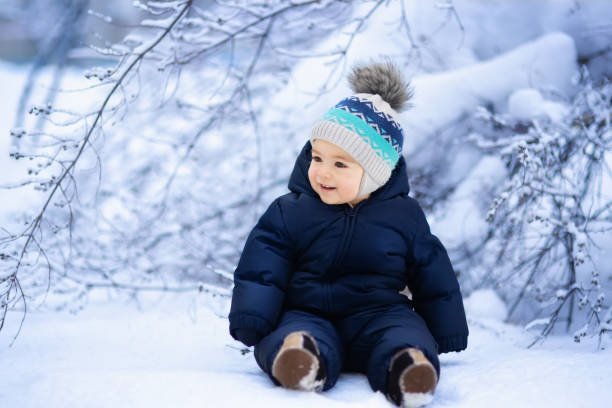 Baby wearing a heavy insulated winter coat with hood in snowy outdoor setting