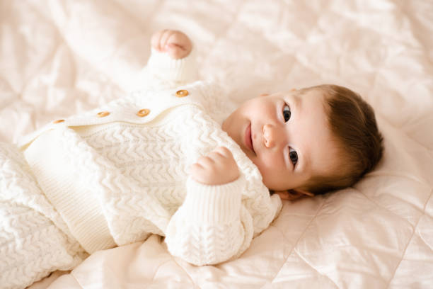 Baby wearing pastel knit cardigan trending 2025 baby knitwear.