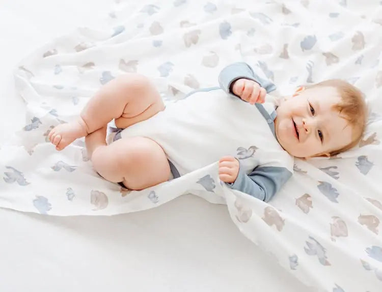 Smiling baby in a breathable cotton top, resting comfortably.