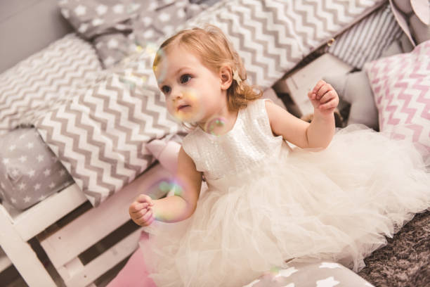 Baby wearing a soft, elegant dress at a family celebration.