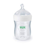 Clear baby bottle with white cap and green 'NUK' logo on a white background