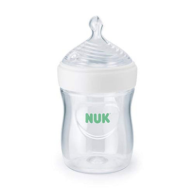 Clear baby bottle with white cap and green 'NUK' logo on a white background