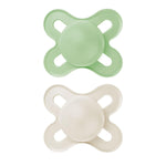 Two green and white baby pacifiers on a white background
