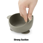 Green suction cup with a hand demonstrating its strong suction on a white background