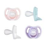 Four pastel-colored pacifiers on a white background