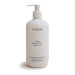White lotion bottle with pump labeled 'mushie' on a white background