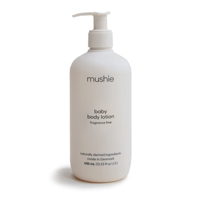 White lotion bottle with pump labeled 'mushie' on a white background