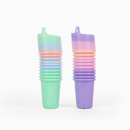 Stacks of pastel-colored sippy cups on a white background