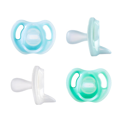 Four pacifiers in different colors on a white background