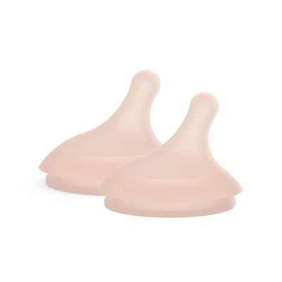 Three beige silicone teats on a white background