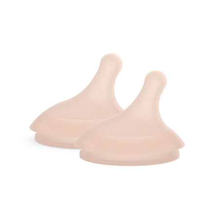 Three beige silicone teats on a white background