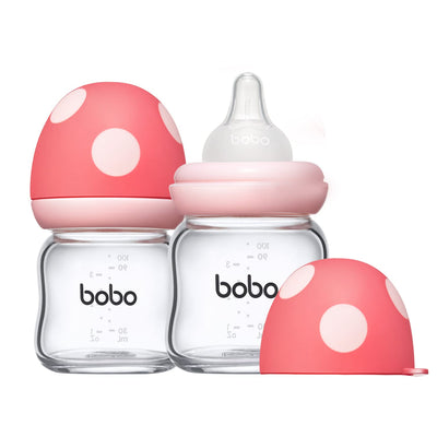 Two baby bottles with pink caps and clear bodies, featuring the brand 'bobo', on a white background.