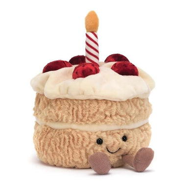 Plush toy cake with a candle on a white background