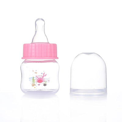 Baby bottle with pink cap and clear cover on a white background
