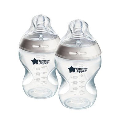 Two Tommee Tippee baby bottles with silver caps on a white background