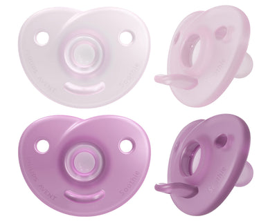 Four purple and white baby pacifiers on a white background