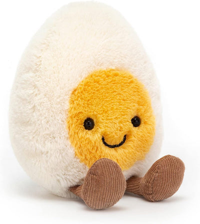 Plush toy resembling a boiled egg with a smiling face on a white background