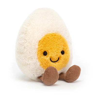 Plush toy resembling a boiled egg with a smiling face on a white background