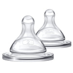 Two clear baby bottle nipples on a white background
