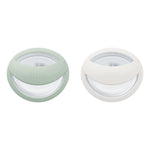 Two small round containers with green and white lids on a white background