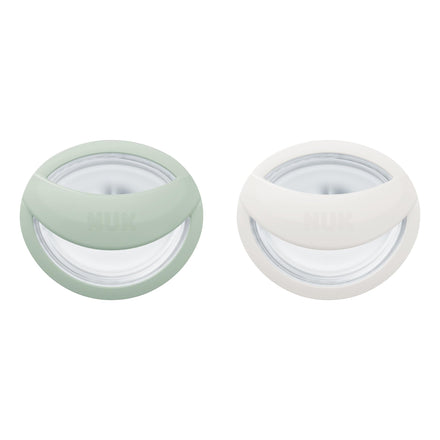 Two small round containers with green and white lids on a white background