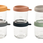 Set of glass jars with colorful lids on a white background