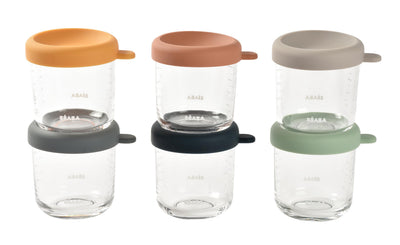 Set of glass jars with colorful lids on a white background