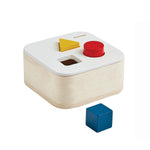 Wooden toy with shape-sorting feature and a blue block on a white background