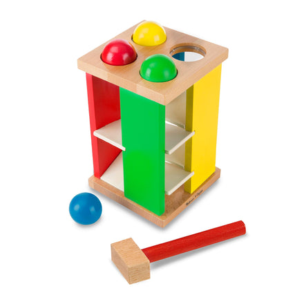 Colorful wooden shape sorter with balls and a hammer on a white background