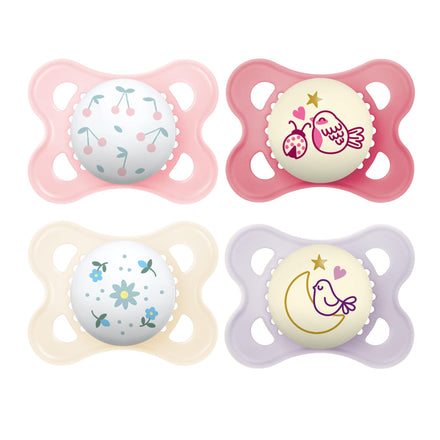 Four baby pacifiers with colorful designs on a white background