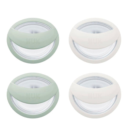Four round containers with green and white lids on a white background