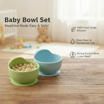 Two baby bowls, one green and one blue, on a wooden surface with a baby's crib and toys in the background.