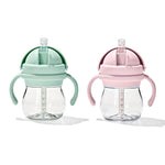 Two baby sippy cups, one green and one pink, on a white background.