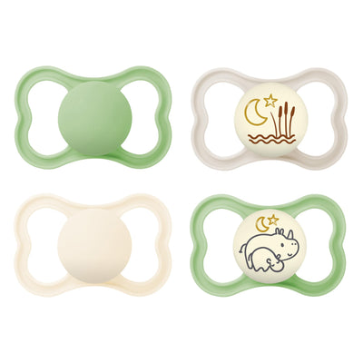 Four baby pacifiers with different designs on a white background
