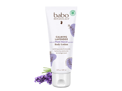 Babo Botanicals Calming Lavender body lotion on a white background with lavender flowers.