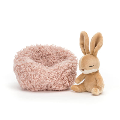 Small plush chair with a fluffy texture next to a plush rabbit toy on a white background
