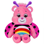 Pink plush toy with purple antennae and rainbow body on a white background