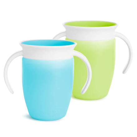 Two children's cups, one blue and one green, with white handles on a white background.