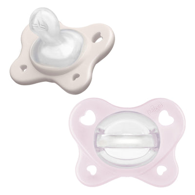 Two baby pacifiers, one white and one pink, on a white background.