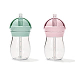 Two clear sippy cups with green and pink lids on a white background