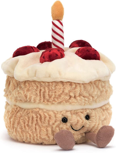 Plush toy cake with a candle on a white background