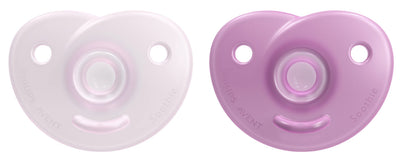 Two baby pacifiers, one white and one purple, on a white background.
