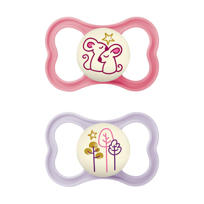 Two baby pacifiers with pink and purple shells on a white background