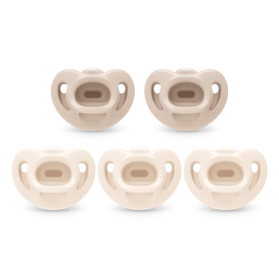 Set of five beige baby pacifiers on a white background