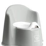Gray potty chair with white seat on a white background, featuring the BABYBJöRN logo.