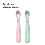 Set of two silicone spoons, one pink and one green, on a white background.