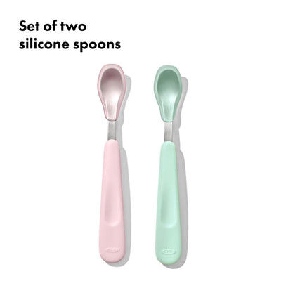 Set of two silicone spoons, one pink and one green, on a white background.