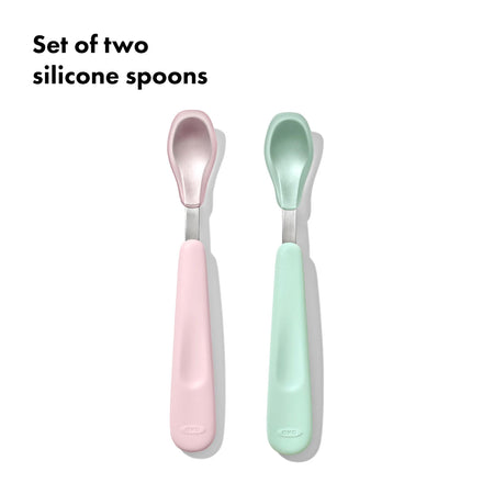 Set of two silicone spoons, one pink and one green, on a white background.