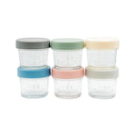 Set of four clear glass jars with colorful lids on a white background