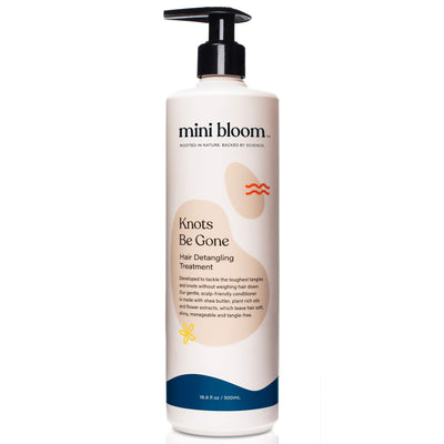 Bottle of 'mini bloom' Knots Be Gone Hair Detangling Treatment on a white background